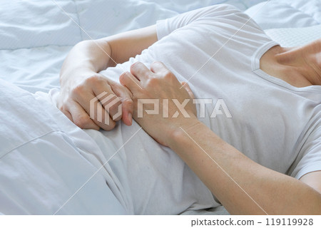Young man uses his hands to hold his stomach and has a severe stomachache.on isolated white background 119119928