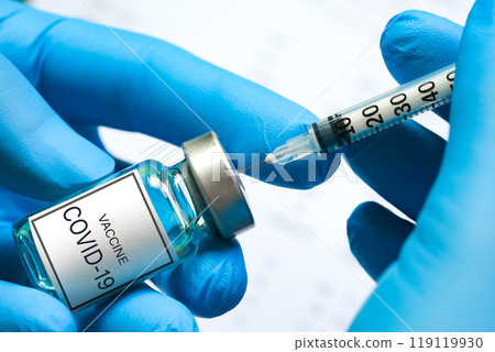 doctor's hand holds a syringe and a blue vaccine bottle at the hospital. Health and medical concepts. 119119930