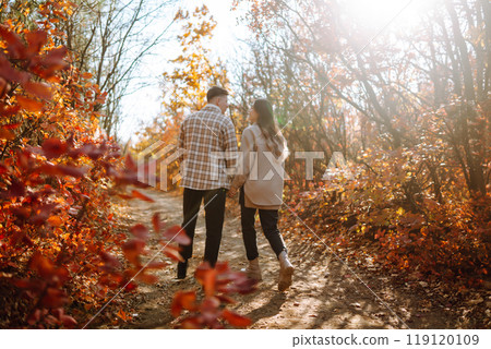 Couple in love newlyweds in casual clothes travel together, hike and walk in autumn forest in nature Couple in love newlyweds in casual clothes travel together, hike and walk in autumn forest in nature 119120109