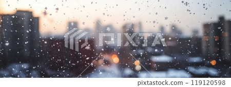 Snowy city view from a window with snowflakes and glowing bokeh lights. Perfect winter scene for Christmas and New Year backgrounds. 119120598