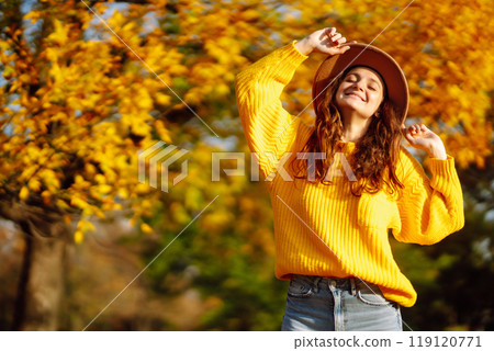 Young woman in a yellow sweater and jeans resting in nature. Fashion, style concept. People, lifestyle. Young woman in a yellow sweater and jeans resting in nature. Fashion, style concept. People, lifestyle. 119120771