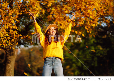 Young woman in a yellow sweater and jeans resting in nature. Fashion, style concept. People, lifestyle. 119120775