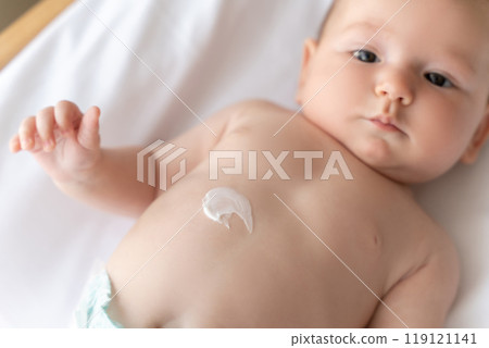 Newborn baby lying on bed with cream on his tiny baby Newborn baby lying on bed with cream on his tiny baby 119121141