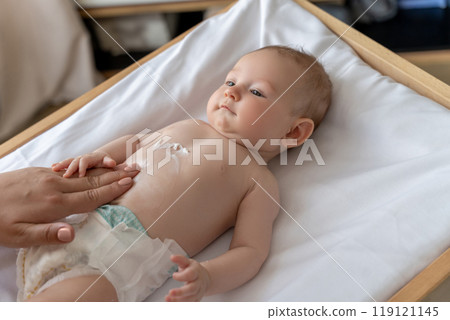 Mother using cream for taking care of newborn baby body 119121145
