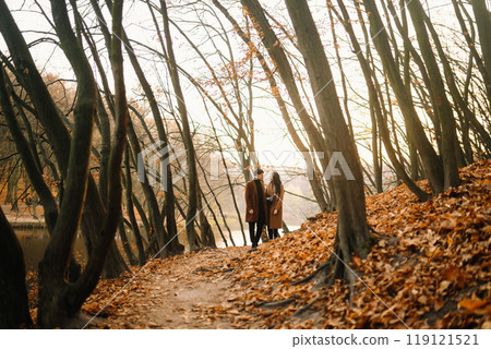 Young couple in love walking in the park on a autumn day. Enjoying time together. Young couple in love walking in the park on a autumn day. Enjoying time together. 119121521