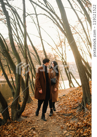 Young couple in love walking in the park on a autumn day. Enjoying time together. Young couple in love walking in the park on a autumn day. Enjoying time together. 119121522