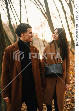 Young couple in love walking in the park on a autumn day. Enjoying time together. Young couple in love walking in the park on a autumn day. Enjoying time together. 119121523
