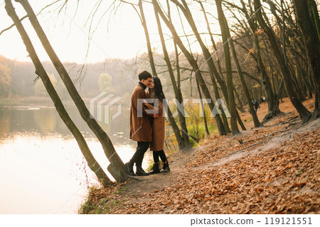 Young couple in love walking in the park on a autumn day. Enjoying time together. Young couple in love walking in the park on a autumn day. Enjoying time together. 119121551