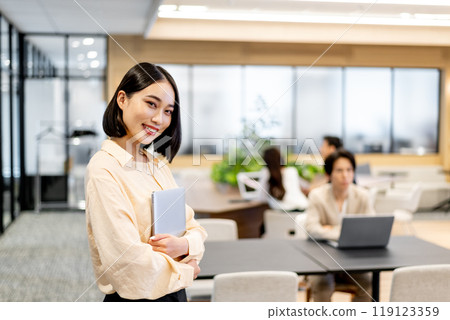 Smiling woman holding a laptop 119123359