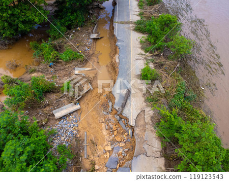Landslides caused by heavy rains have caused the asphalt roads to crack. Natural disasters from flooding have damaged and cut off the road surface along the river. 119123543