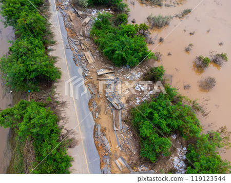 Landslides caused by heavy rains have caused the asphalt roads to crack. Natural disasters from flooding have damaged and cut off the road surface along the river. Landslides caused by heavy rains have caused the asphalt roads to crack. Natural disasters from flooding have damaged and cut off the road surface along the river. 119123544