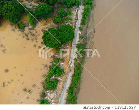 Landslides caused by heavy rains have caused the asphalt roads to crack. Natural disasters from flooding have damaged and cut off the road surface along the river. Landslides caused by heavy rains have caused the asphalt roads to crack. Natural disasters from flooding have damaged and cut off the road surface along the river. 119123557