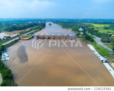 Aerial view of the dam's floodgates with rapid flow of water in the rainy season. Dam water release, dam overcapacity after heavy rain. 119123562