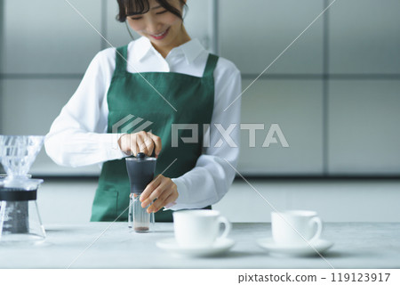 A young female sales clerk brewing coffee on a weekend morning A young female sales clerk brewing coffee on a weekend morning 119123917