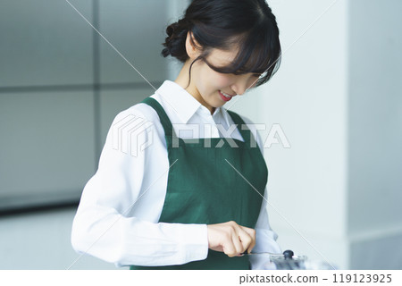 A young female sales clerk brewing coffee on a weekend morning A young female sales clerk brewing coffee on a weekend morning 119123925