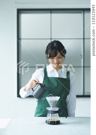 A young female sales clerk brewing coffee on a weekend morning A young female sales clerk brewing coffee on a weekend morning 119123945