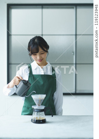 週末早上，一位年輕的女店員正在煮咖啡 119123948