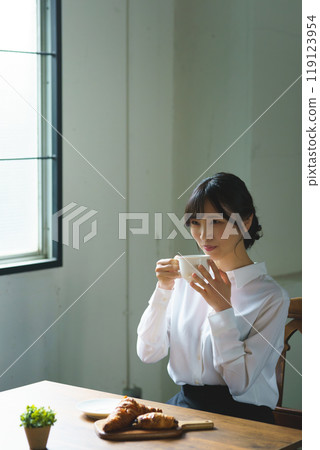Young woman drinking a cup of coffee in a calm atmosphere in the morning 119123954