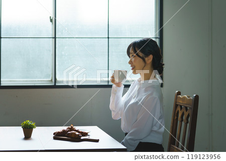 Young woman drinking a cup of coffee in a calm atmosphere in the morning 119123956