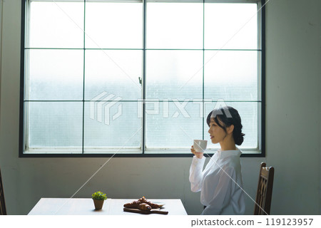 Young woman drinking a cup of coffee in a calm atmosphere in the morning 119123957