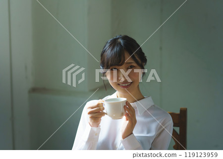 Young woman drinking a cup of coffee in a calm atmosphere in the morning 119123959
