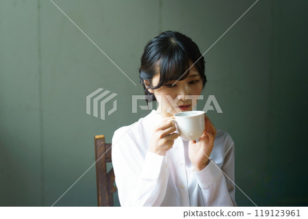 早晨,年輕女子在平靜的氣氛中喝一杯咖啡 早晨,年輕女子在平靜的氣氛中喝一杯咖啡 119123961