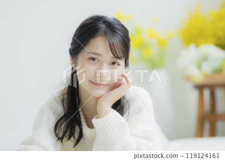 A woman lying down in a white knitted sweater 119124161