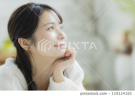 A woman lying down in a white knitted sweater 119124165