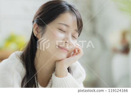 A woman lying down in a white knitted sweater 119124166