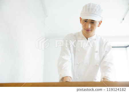 A young man wearing a chef's coat A young man wearing a chef's coat 119124182
