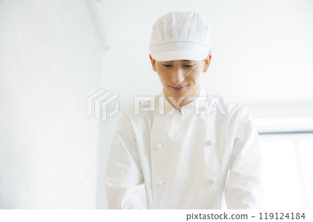 A young man wearing a chef's coat 119124184