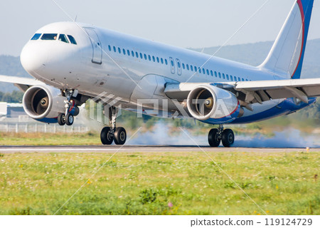 Passenger airplane lands. Touching the runway with smoke 119124729