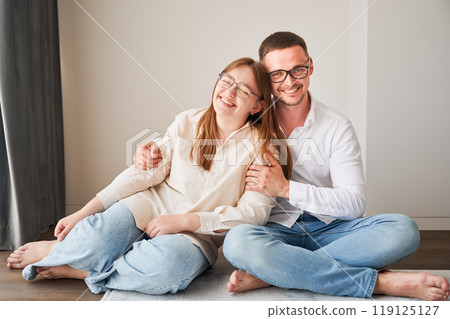 Portrait of father and teenage daughter hugging each other at home. Cute moment of dad and child in glasses showing their love to each other. Lovely spending time with family. 119125127