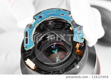 the hands of the master with gloves and a broken lens of a professional camera. the hands of the master with gloves and a broken lens of a professional camera. 119125958