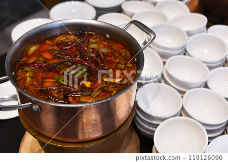 Asian spicy soup in the pot with many bowls Asian spicy soup in the pot with many bowls 119126090