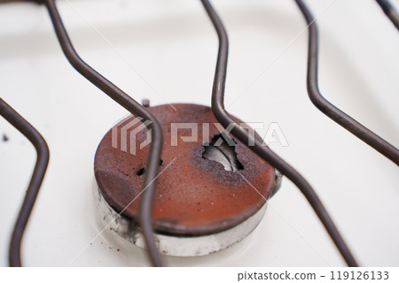 An old broken rusted burner of a gas stove. An old broken rusted burner of a gas stove. 119126133