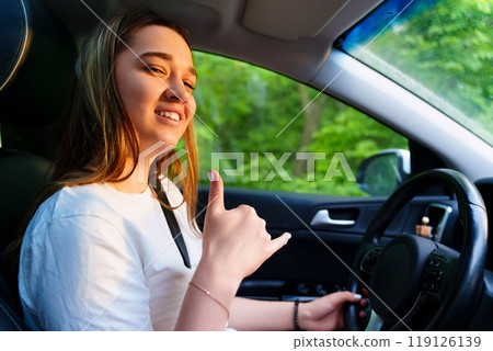 A young girl is driving a car. an inexperienced driver. A young girl is driving a car. an inexperienced driver. 119126139