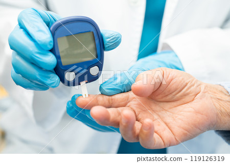 Doctor check diabetes from finger blood sugar level with finger lancet. 119126319