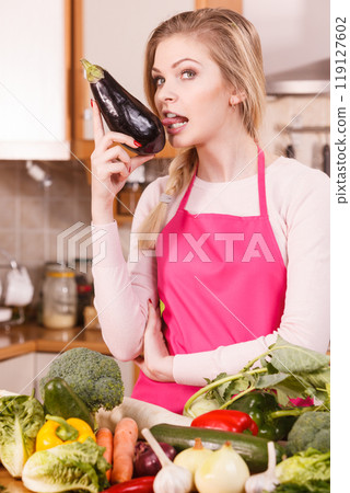 Woman holding biting eggplant. 119127602