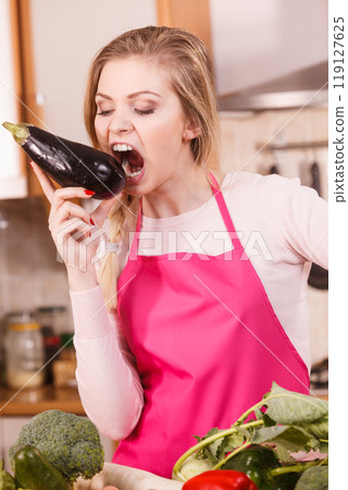 Woman holding biting eggplant. 119127625