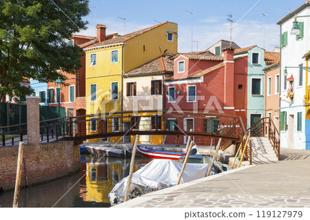 Multicolored colorful houses in Venice on the island of Burano. Narrow canal with motor boats along the houses. Summer sunny day. Selective focus. Multicolored colorful houses in Venice on the island of Burano. Narrow canal with motor boats along the houses. Summer sunny day. Selective focus. 119127979