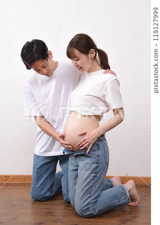 一個大肚子的年輕孕婦和她的丈夫擁抱 一個大肚子的年輕孕婦和她的丈夫擁抱 119127999