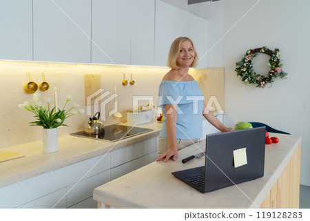 Healthy Cooking in a Modern Kitchen A Woman Skillfully Preparing Fresh, Colorful Vegetables with Care 119128283