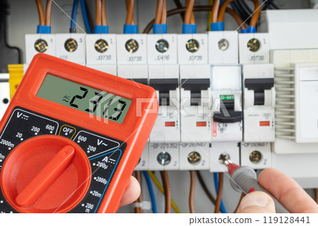 Hand Testing Electrical Circuit with Multimeter 119128441
