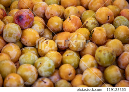 yellow plums displayed on a farmer's market counter 119128863