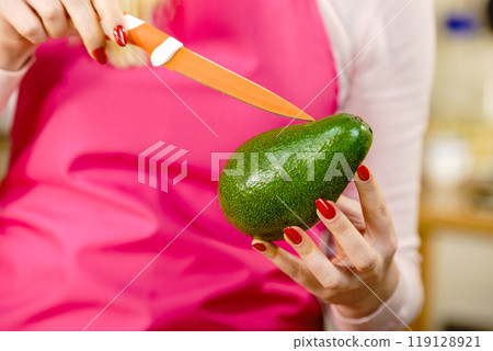 Woman cutting avocado Woman cutting avocado 119128921