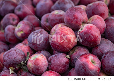 red apples displayed on a farmer's market counter 119128942