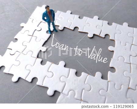 Text Loan to Value written on gray background with white puzzle and miniature people. Text Loan to Value written on gray background with white puzzle and miniature people. 119129065