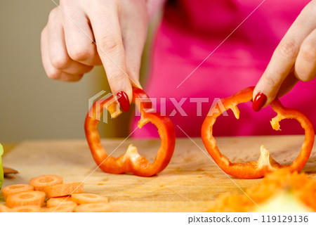 Woman showing sliced red bell pepper rings 119129136