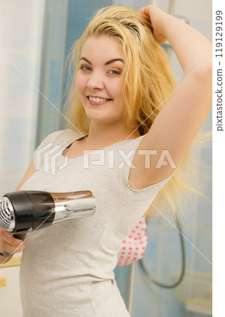 Woman drying sweat stains using hair dryer 119129199